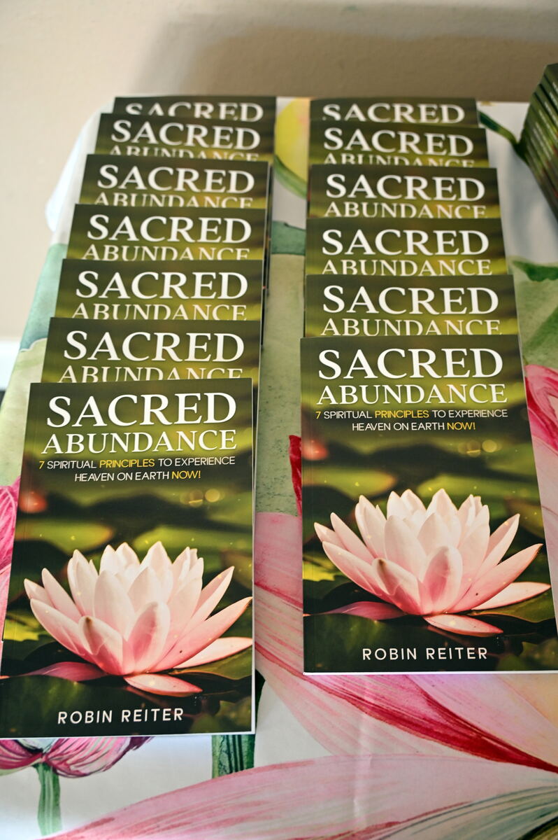 Stacked copies of Sacred Abundance by Robin Reiter, the lotus cover repeated down the pile