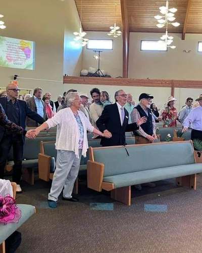 The congregation gathered in the sanctuary, holding hands