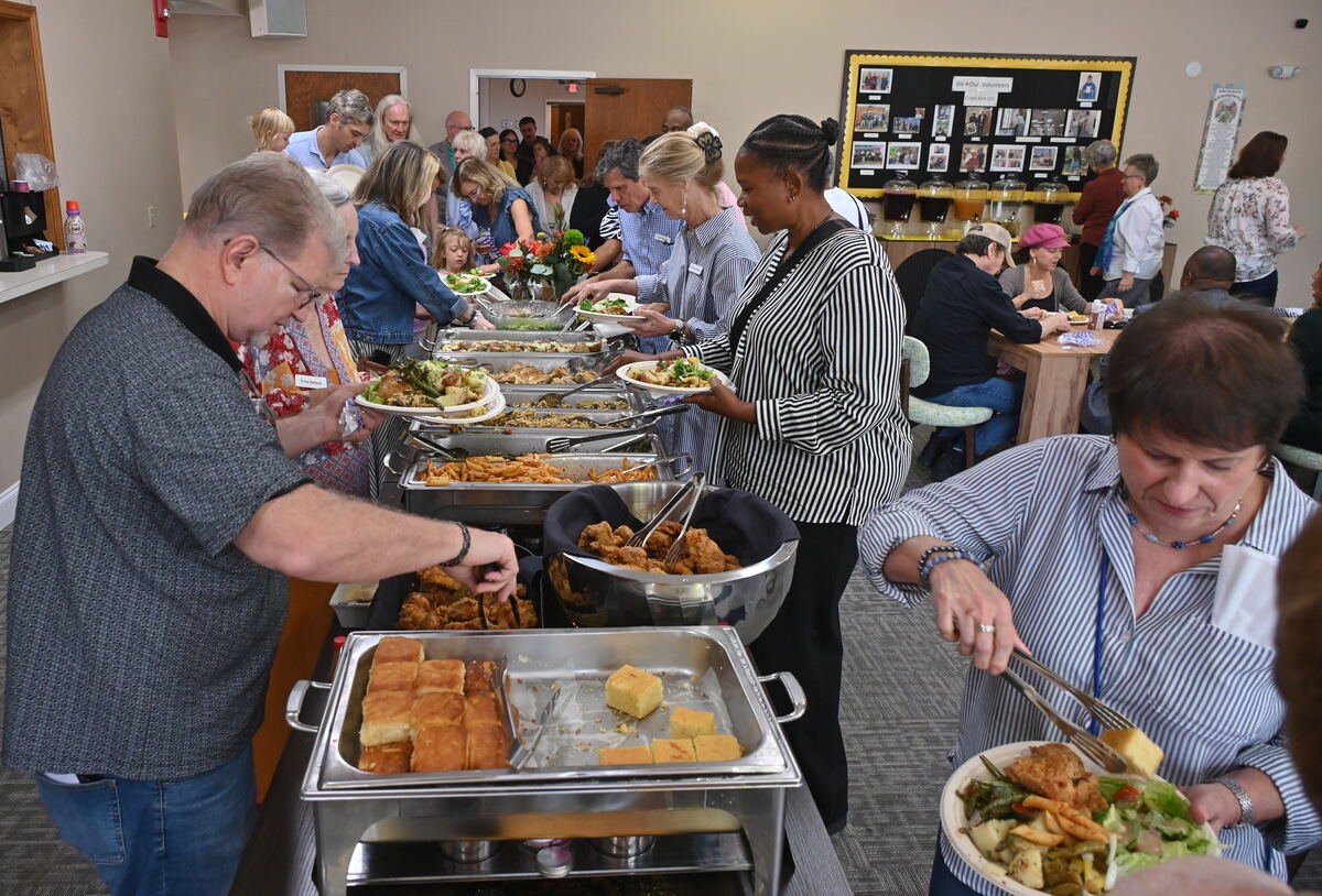 The lunch line in Fillmore Fellowship Hall, chafing dishes along the table and plates being filled
